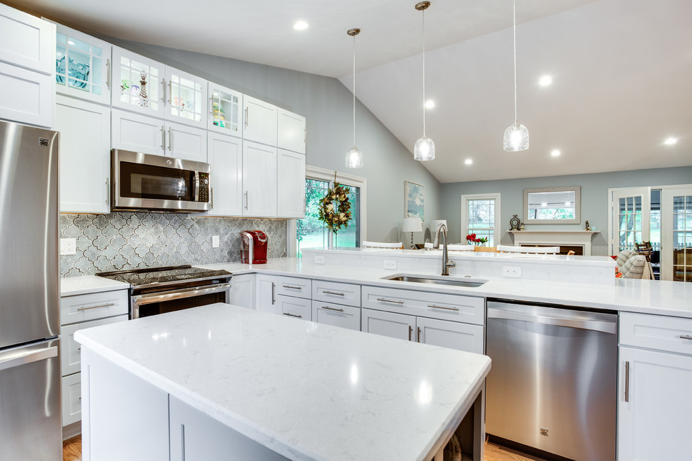 Design ideas for a large transitional u-shaped kitchen in DC Metro with an undermount sink, shaker cabinets, quartz benchtops, stainless steel appliances, medium hardwood floors, with island and white benchtop.