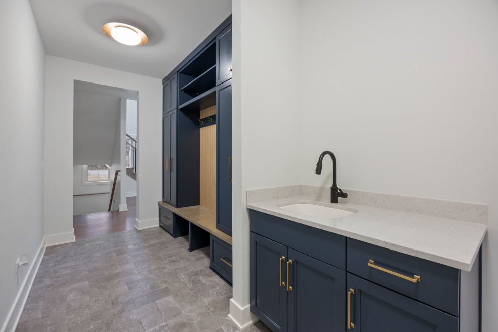 Inspiration for a mid-sized transitional porcelain tile, gray floor and wall paneling mudroom remodel in Chicago with white walls and a white front door