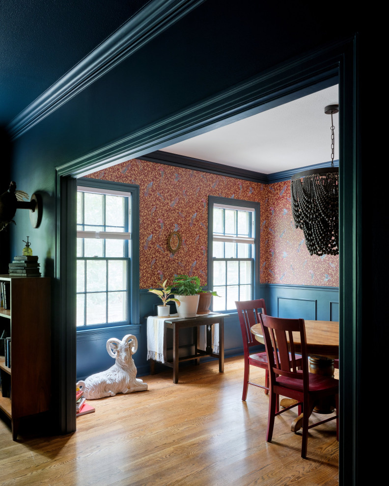 Пример оригинального дизайна: кухня-столовая в современном стиле с синими стенами, паркетным полом среднего тона, стандартным камином, фасадом камина из камня, многоуровневым потолком, панелями на стенах и коричневым полом