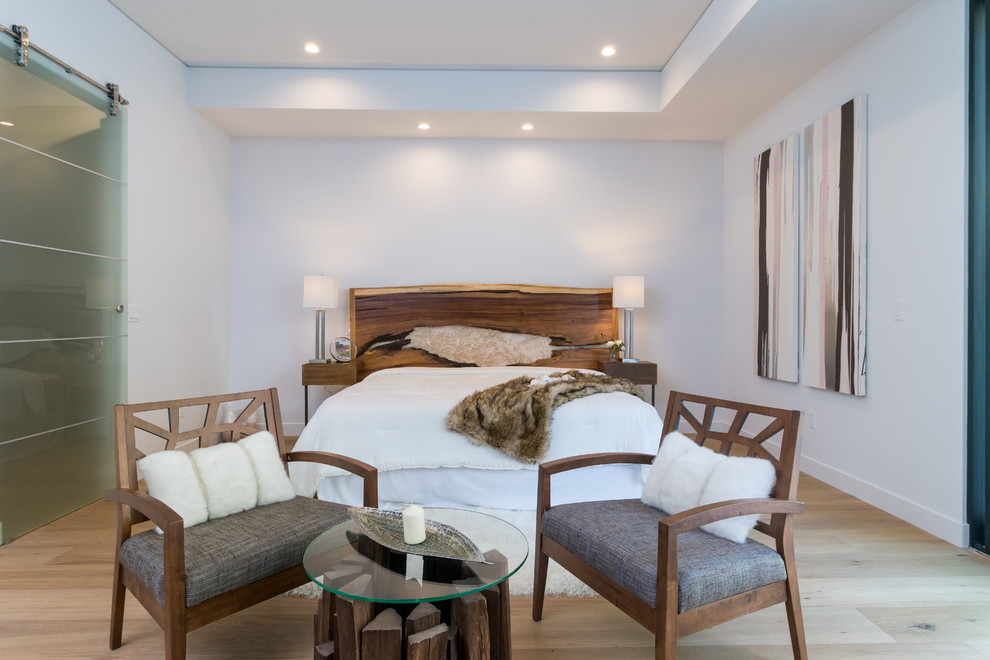 Trendy master light wood floor and beige floor bedroom photo in Los Angeles with white walls