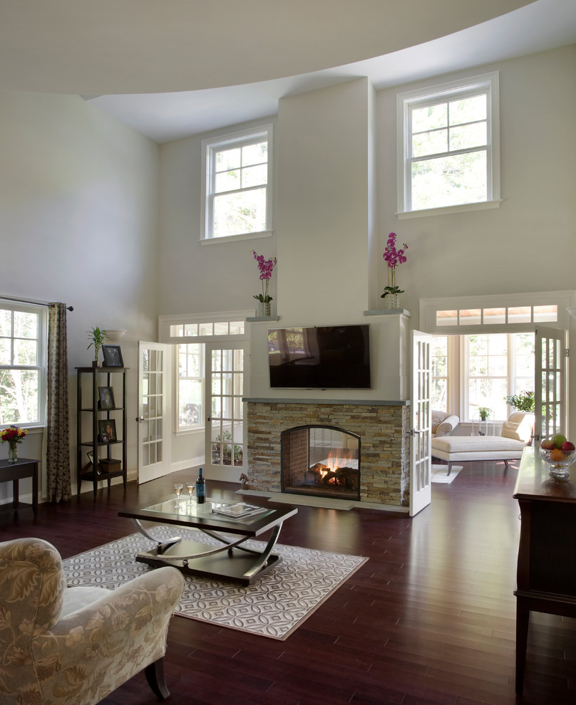 Large transitional open concept dark wood floor family room photo in Boston with beige walls, a two-sided fireplace, a stone fireplace and a wall-mounted tv