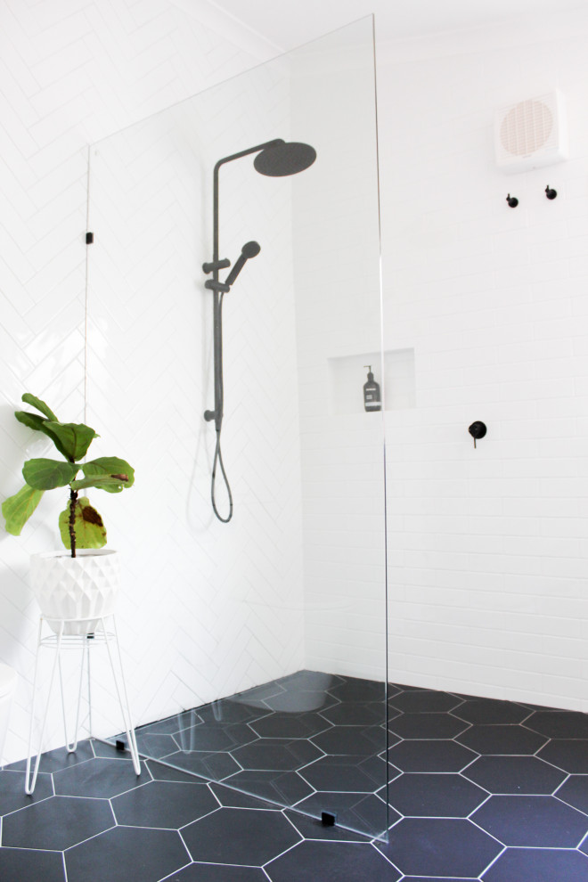 Large modern master bathroom in Perth with shaker cabinets, white cabinets, an open shower, a one-piece toilet, white tile, ceramic tile, white walls, porcelain floors, a drop-in sink, engineered quartz benchtops, black floor, an open shower and grey benchtops.
