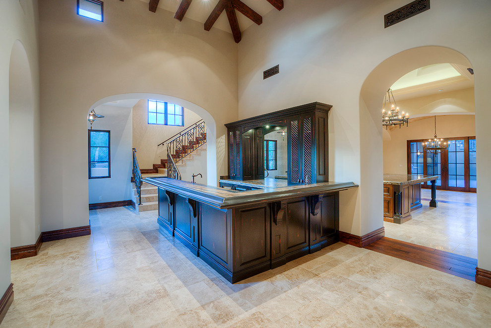 This is an example of a large transitional u-shaped seated home bar in Phoenix with a drop-in sink, recessed-panel cabinets, dark wood cabinets, terrazzo benchtops, mirror splashback and ceramic floors.