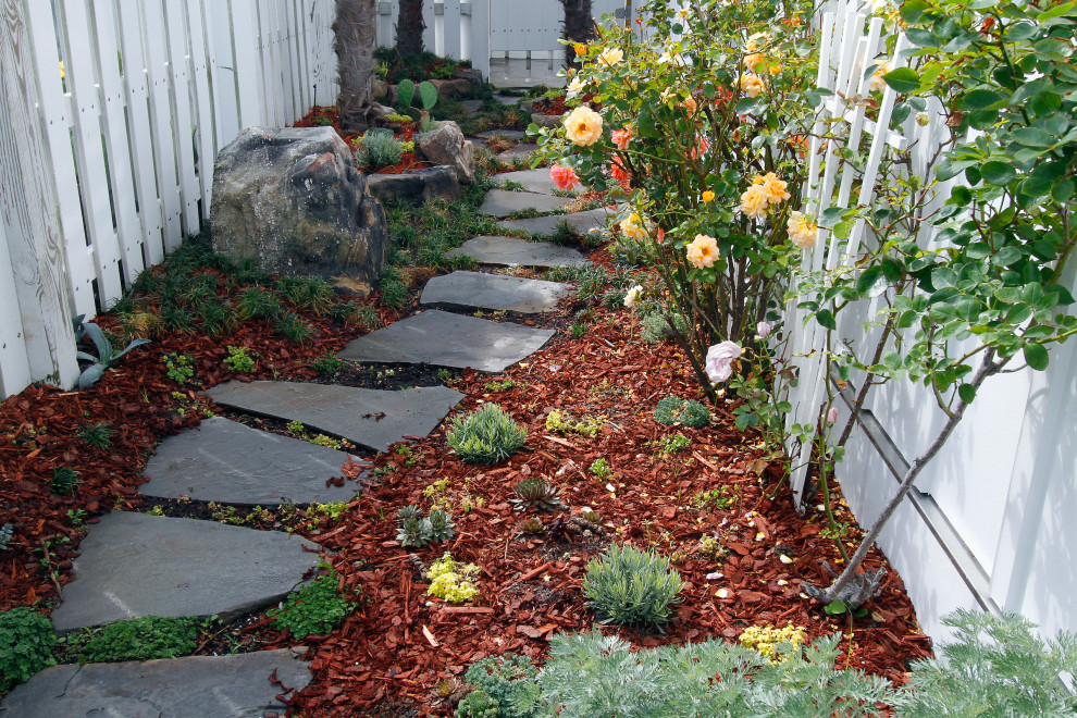Inspiration for a side yard garden in Other with with path and natural stone pavers.