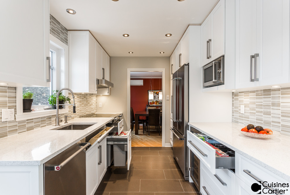 This is an example of a small scandinavian galley separate kitchen in Montreal with an undermount sink, shaker cabinets, white cabinets, quartzite benchtops, grey splashback, glass tile splashback, stainless steel appliances, ceramic floors and no island.