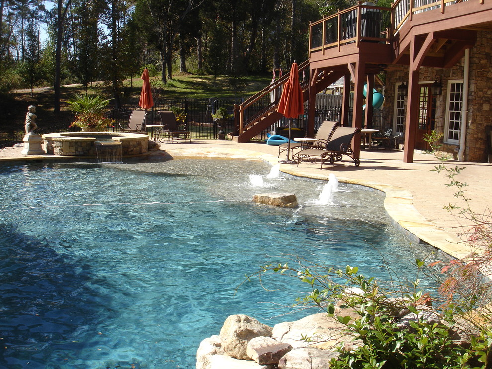 Inspiration for a large mediterranean backyard custom-shaped pool in Atlanta with a hot tub and brick pavers.
