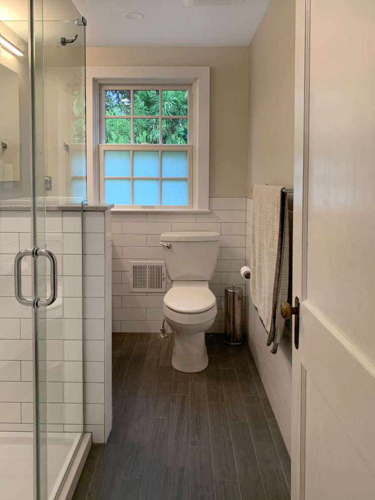 Design ideas for a mid-sized transitional 3/4 bathroom in Philadelphia with shaker cabinets, medium wood cabinets, a one-piece toilet, beige tile, porcelain tile, beige walls, porcelain floors, engineered quartz benchtops, grey floor and grey benchtops.