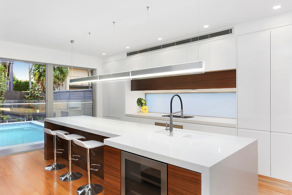 Inspiration for a contemporary kitchen in Sydney with an undermount sink, flat-panel cabinets, white cabinets, blue splashback, medium hardwood floors and with island.