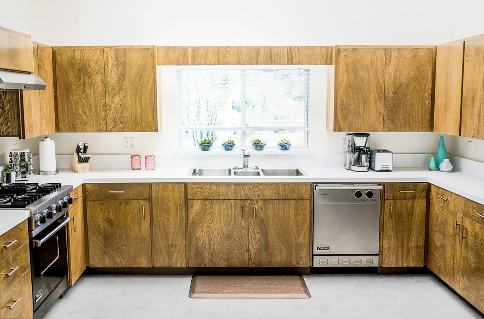Design ideas for a midcentury u-shaped kitchen in Other with a triple-bowl sink, flat-panel cabinets, medium wood cabinets, stainless steel appliances, concrete floors, no island and grey floor.