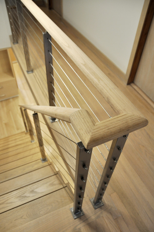 Immagine di una scala a rampa dritta minimalista di medie dimensioni con pedata in legno, nessuna alzata e parapetto in cavi