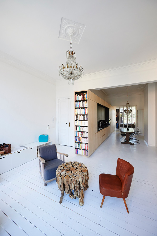 Photo of a scandinavian family room in Brussels with a library, white walls and painted wood floors.
