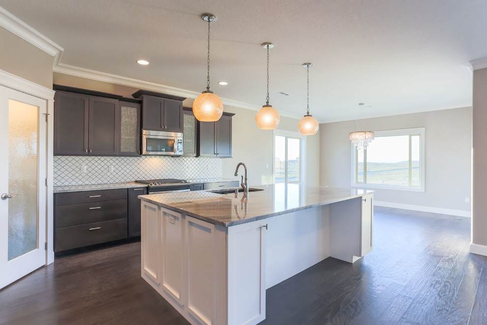Example of a mid-sized transitional l-shaped dark wood floor open concept kitchen design in Seattle with an undermount sink, shaker cabinets, dark wood cabinets, granite countertops, white backsplash, porcelain backsplash, stainless steel appliances and an island