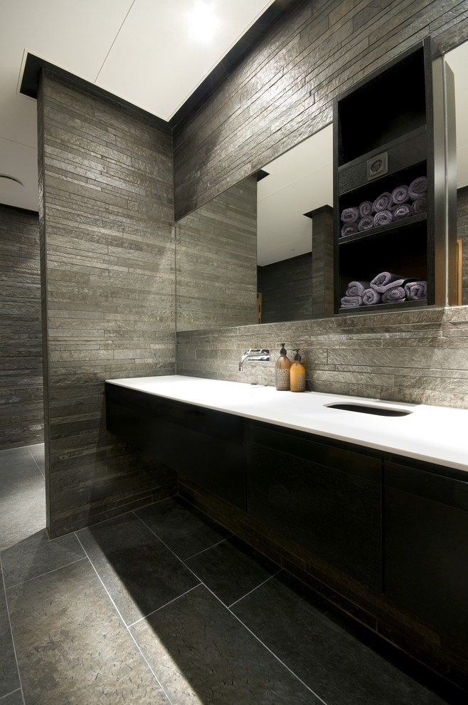 Contemporary bathroom in Other with a curbless shower, stone tile, grey walls and a vessel sink.