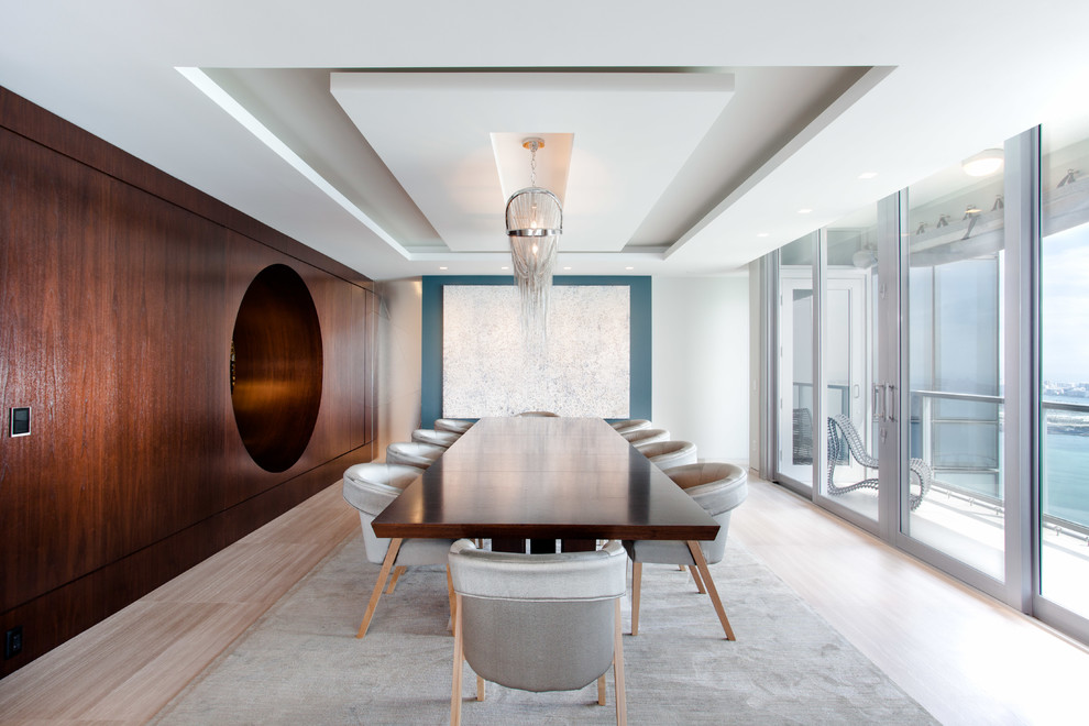 Contemporary dining room in Miami with white walls and light hardwood floors.