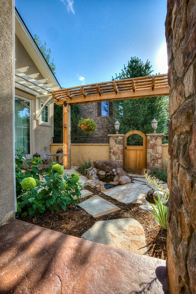 Photo of a mid-sized transitional partial sun front yard stone walkway in Denver.