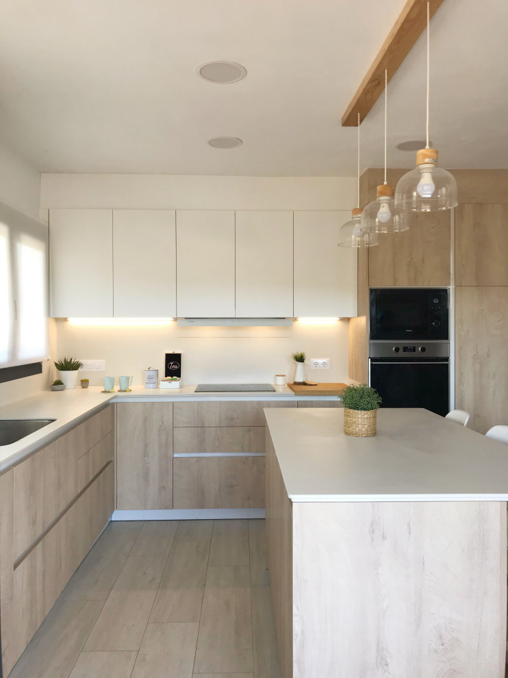 Mid-sized scandinavian l-shaped eat-in kitchen in Barcelona with a single-bowl sink, flat-panel cabinets, light wood cabinets, concrete benchtops, beige splashback, stainless steel appliances, ceramic floors, with island, brown floor and beige benchtop.