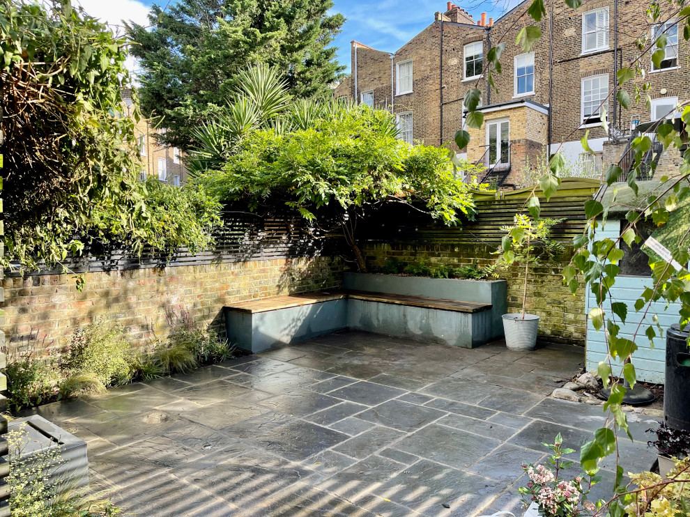Foto di un giardino esposto a mezz'ombra di medie dimensioni e dietro casa in estate con pavimentazioni in pietra naturale e recinzione in legno