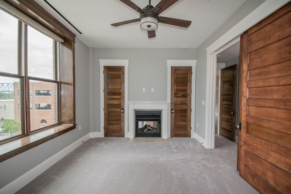 Photo of a mid-sized country master bedroom in Louisville with grey walls, carpet, a two-sided fireplace, a tile fireplace surround and grey floor.