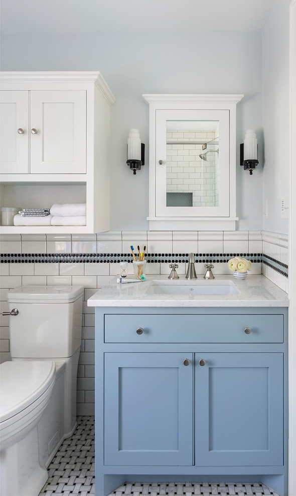 Small traditional kids bathroom in Minneapolis with blue cabinets, a corner shower, a two-piece toilet, black and white tile, ceramic tile, blue walls, marble floors, an undermount sink, engineered quartz benchtops, grey floor, a hinged shower door, white benchtops and shaker cabinets.