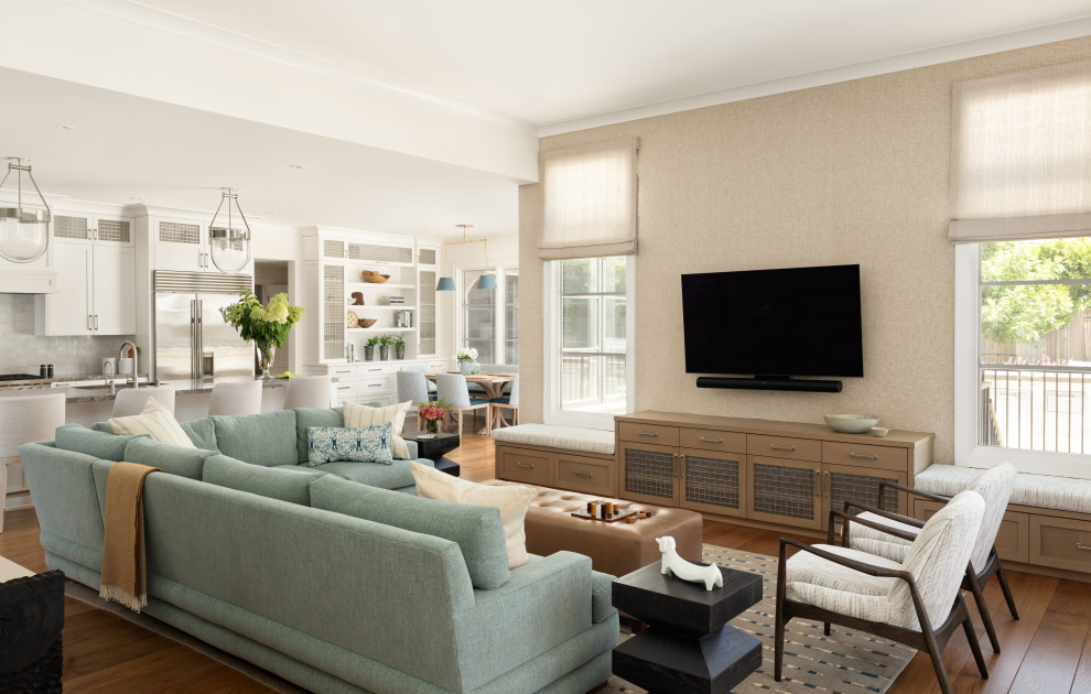 Modelo de salón abierto clásico renovado grande con suelo de madera en tonos medios, papel pintado y televisor colgado en la pared