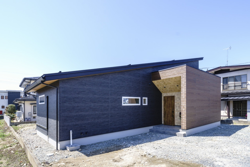 Ejemplo de fachada de casa negra y negra minimalista de tamaño medio de una planta con tejado de un solo tendido y tejado de metal