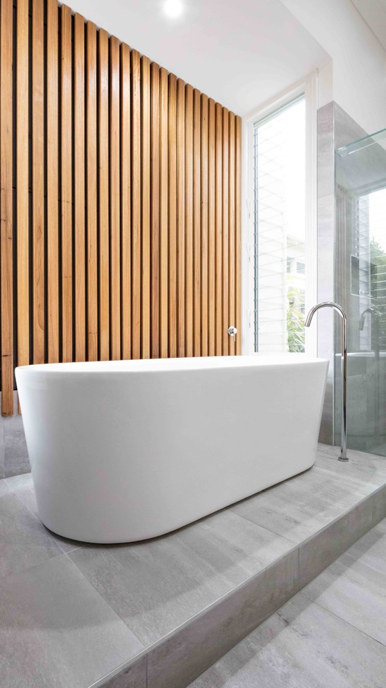 Design ideas for a large contemporary master bathroom in Melbourne with furniture-like cabinets, light wood cabinets, a drop-in tub, a double shower, a wall-mount toilet, white tile, marble, white walls, cement tiles, engineered quartz benchtops, grey floor and a shower curtain.