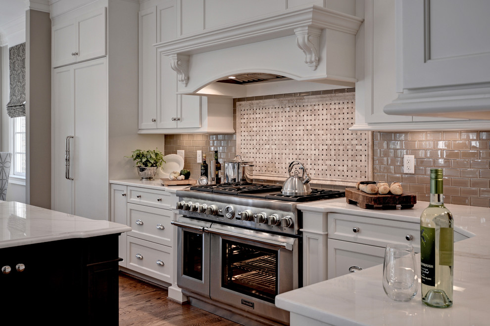 Inspiration for a huge transitional l-shaped medium tone wood floor and brown floor eat-in kitchen remodel with a farmhouse sink, shaker cabinets, white cabinets, marble countertops, beige backsplash, glass tile backsplash, stainless steel appliances and an island