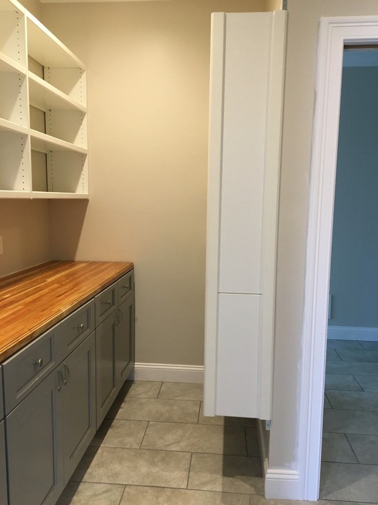 Inspiration for a large traditional single-wall kitchen pantry in Boston with shaker cabinets, blue cabinets, wood benchtops, ceramic floors and grey floor.