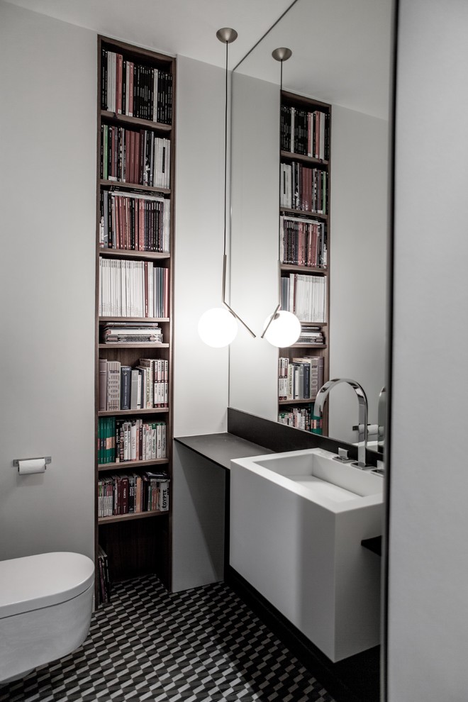 Photo of a large contemporary powder room in Paris with a wall-mount toilet, black and white tile, white walls, ceramic floors, a wall-mount sink, solid surface benchtops and open cabinets.