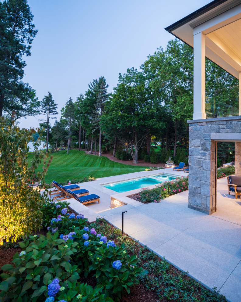 Aménagement d'un très grand piscine avec aménagement paysager arrière moderne rectangle avec des pavés en pierre naturelle.