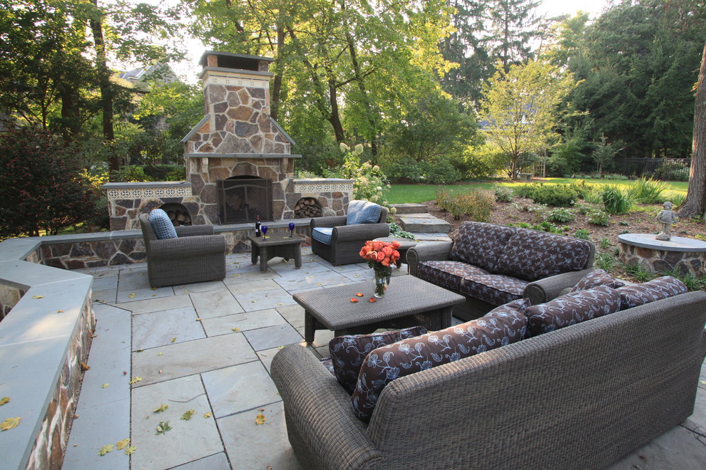 Design ideas for a large traditional backyard patio in New York with a fire feature, natural stone pavers and a pergola.