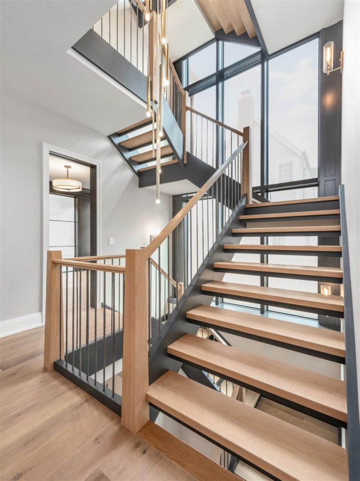 Foto de escalera en U clásica renovada grande sin contrahuella con escalones de madera y barandilla de madera