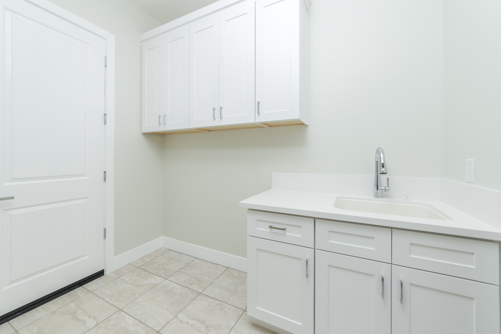 This is an example of a small contemporary single-wall dedicated laundry room in Sacramento with an integrated sink, beaded inset cabinets, white cabinets, quartzite benchtops, grey walls, ceramic floors, a side-by-side washer and dryer, beige floor and white benchtop.