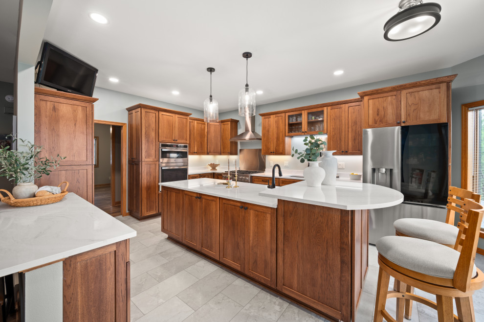 Eat-in kitchen - large transitional u-shaped vinyl floor and gray floor eat-in kitchen idea in Chicago with an undermount sink, shaker cabinets, medium tone wood cabinets, quartz countertops, white backsplash, quartz backsplash, stainless steel appliances, an island and white countertops