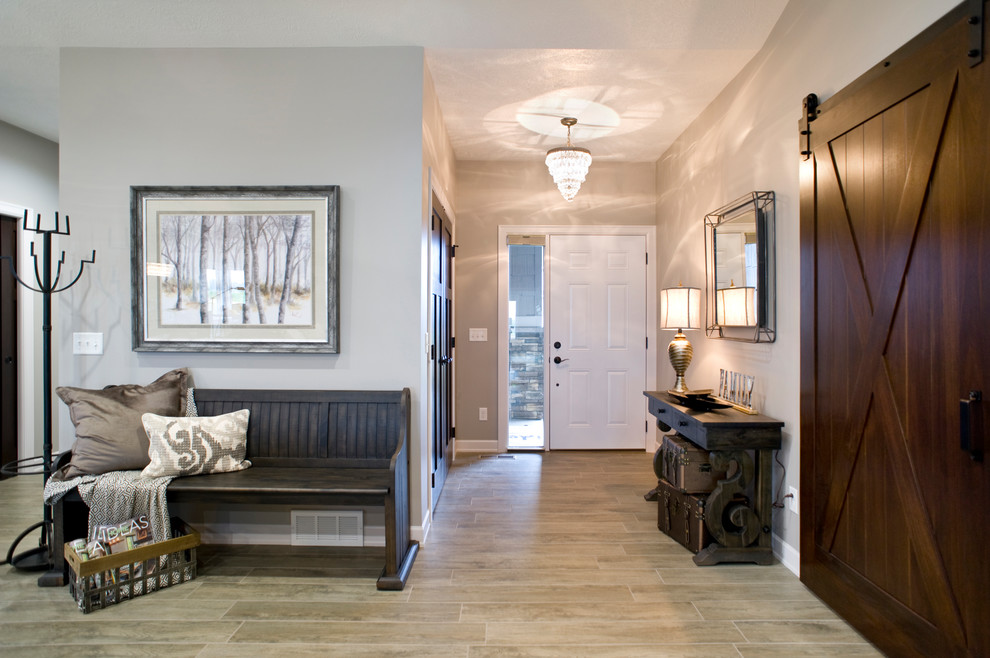 Example of a large eclectic porcelain tile and brown floor foyer design with gray walls and a white front door