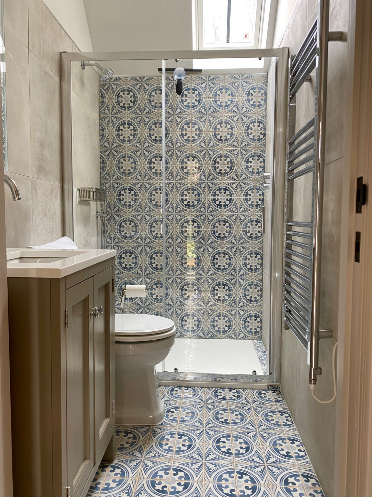 Design ideas for a small country bathroom in Hampshire with shaker cabinets, beige cabinets, blue tile, porcelain tile, white walls, porcelain floors, an undermount sink, engineered quartz benchtops, blue floor, a sliding shower screen, white benchtops, a single vanity, a freestanding vanity and vaulted.