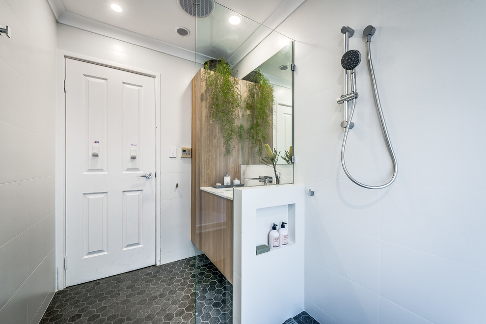 Photo of a mid-sized contemporary master bathroom in Perth with recessed-panel cabinets, medium wood cabinets, a drop-in tub, an open shower, white tile, porcelain tile, white walls, mosaic tile floors, an undermount sink, solid surface benchtops, grey floor, an open shower and multi-coloured benchtops.