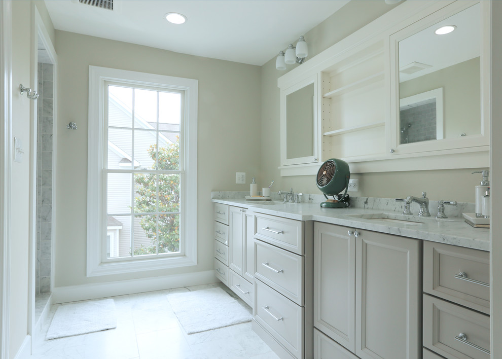 Photo of a mid-sized traditional master bathroom in DC Metro with recessed-panel cabinets, grey cabinets, grey walls, marble floors, an undermount sink, marble benchtops, grey floor, an alcove shower, stone tile and a hinged shower door.