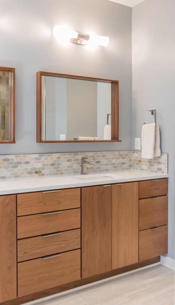 Mid-sized midcentury master bathroom in DC Metro with flat-panel cabinets, medium wood cabinets, a drop-in tub, blue tile, green tile, orange tile, white tile, glass tile, blue walls, porcelain floors, an undermount sink and quartzite benchtops.