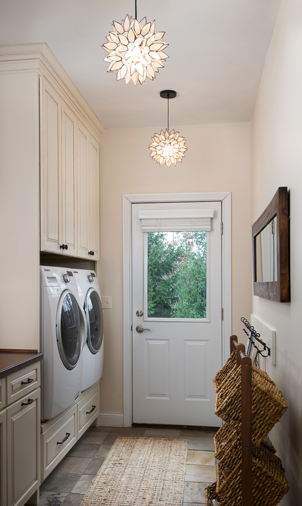 Design ideas for a country laundry room in Cincinnati with wood benchtops, slate floors, a side-by-side washer and dryer, beige cabinets and raised-panel cabinets.