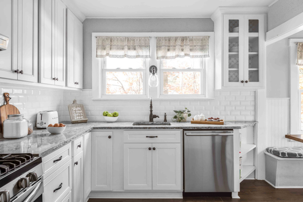 Inspiration for a mid-sized farmhouse l-shaped porcelain tile and brown floor eat-in kitchen remodel in Philadelphia with a single-bowl sink, flat-panel cabinets, white cabinets, quartzite countertops, white backsplash, ceramic backsplash, stainless steel appliances and gray countertops