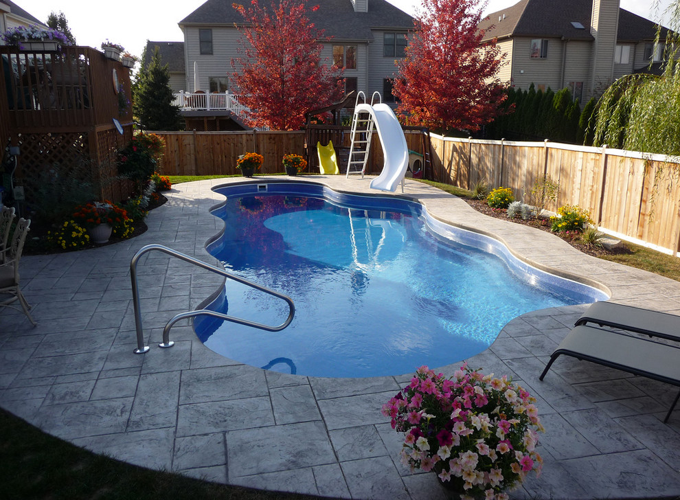 Pool fountain - mid-sized backyard stamped concrete and custom-shaped natural pool fountain idea in Cincinnati