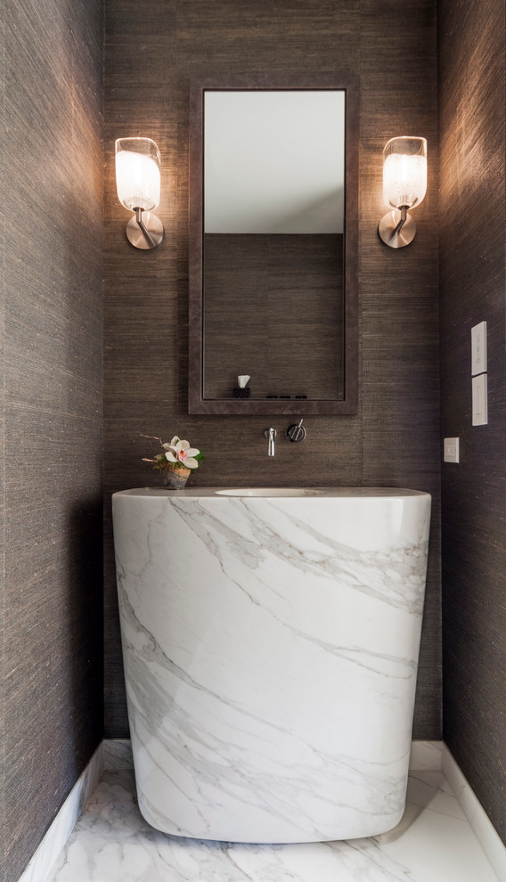 Mid-sized contemporary powder room in Toronto with a pedestal sink, marble benchtops, marble floors and brown walls.
