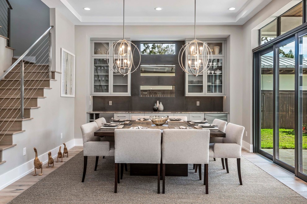 Photo of a large contemporary dining room in Orlando with grey walls, light hardwood floors and no fireplace.