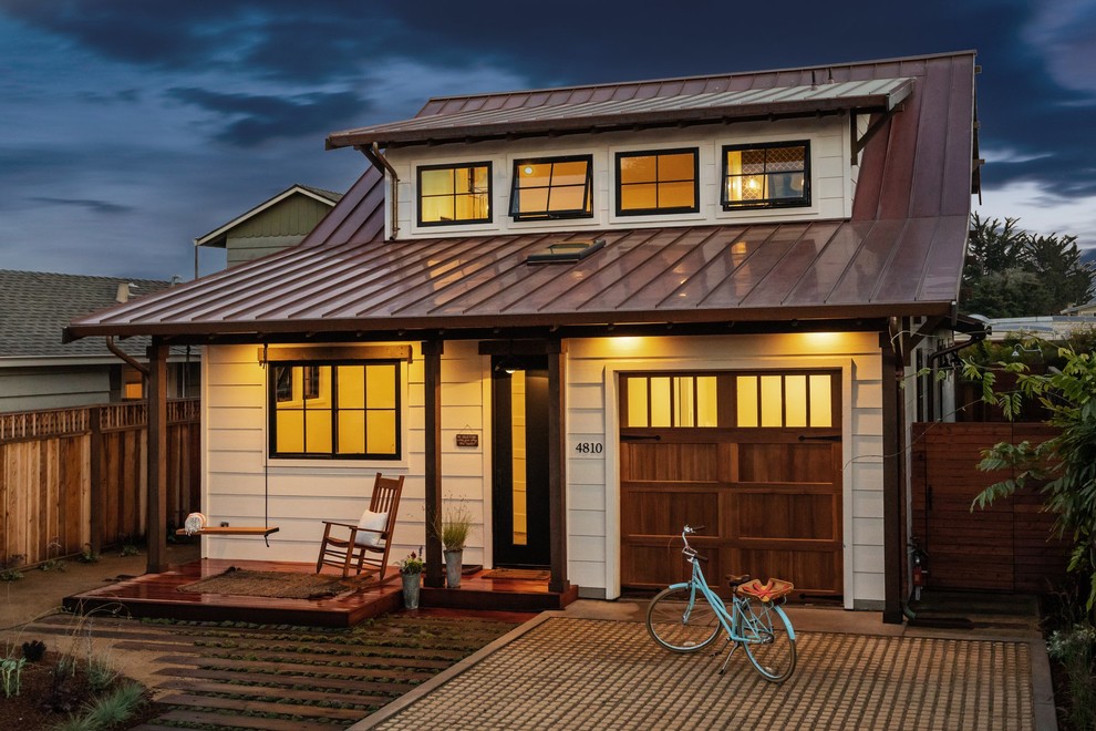 Photo of a beach style two-storey white house exterior in San Francisco with a metal roof.
