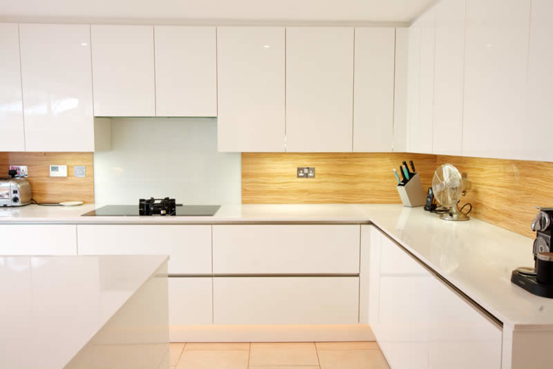 Mid-sized contemporary kitchen in London with white cabinets, with island and glass-front cabinets.