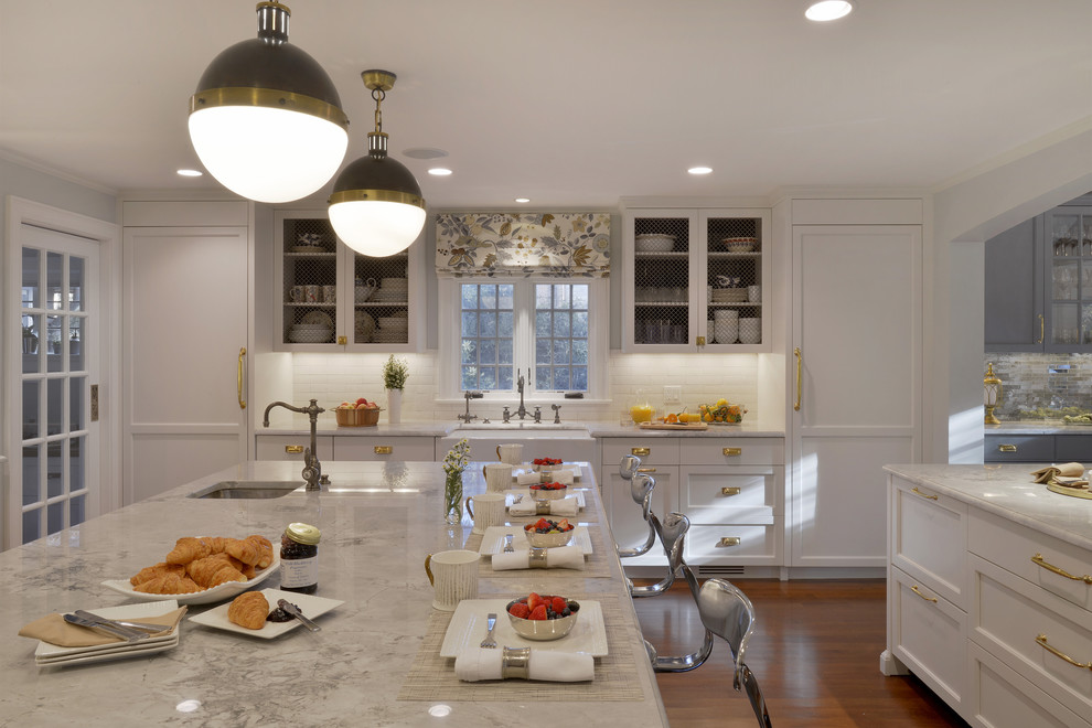 Design ideas for an expansive transitional l-shaped eat-in kitchen in New York with a farmhouse sink, recessed-panel cabinets, white cabinets, quartzite benchtops, white splashback, ceramic splashback, coloured appliances, dark hardwood floors and multiple islands.