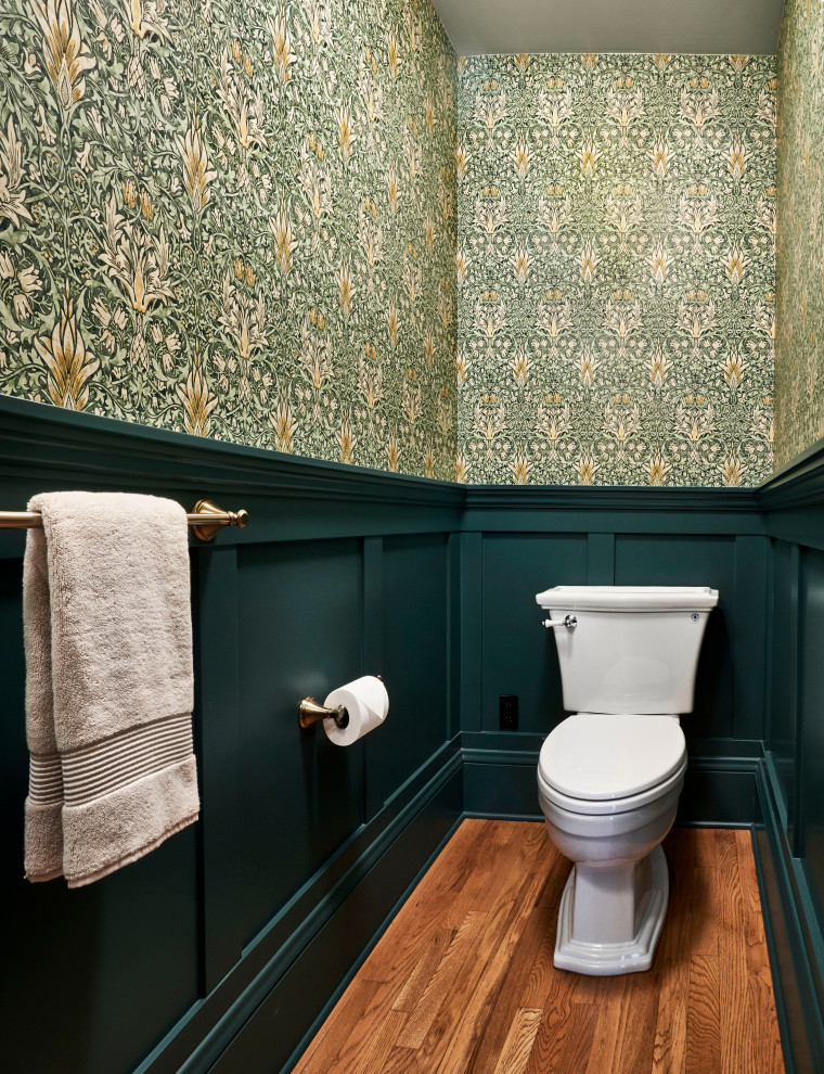 ポートランドにある小さなトラディショナルスタイルのおしゃれなトイレ・洗面所 (白いキャビネット、緑の壁、無垢フローリング、ペデスタルシンク、茶色い床、独立型洗面台、壁紙) の写真