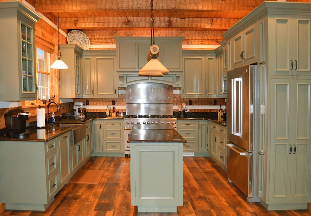 Enclosed kitchen - large rustic u-shaped medium tone wood floor enclosed kitchen idea with a farmhouse sink, green cabinets, granite countertops, stainless steel appliances, an island, recessed-panel cabinets, brown backsplash and wood backsplash
