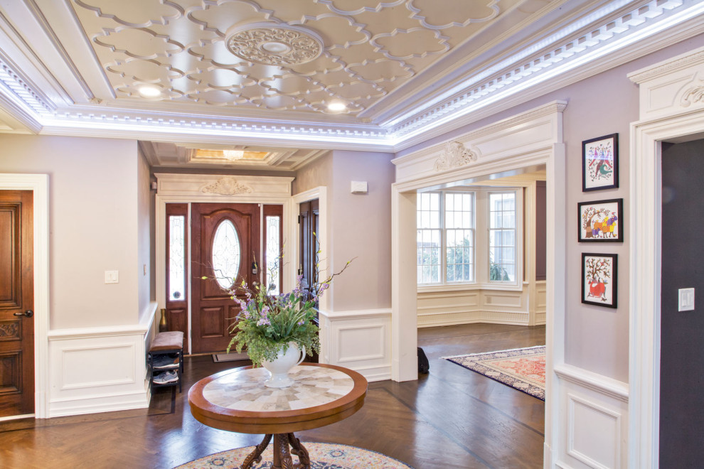 This is an example of a large traditional foyer in Philadelphia with purple walls, dark hardwood floors, a single front door, a brown front door, brown floor, coffered and panelled walls.